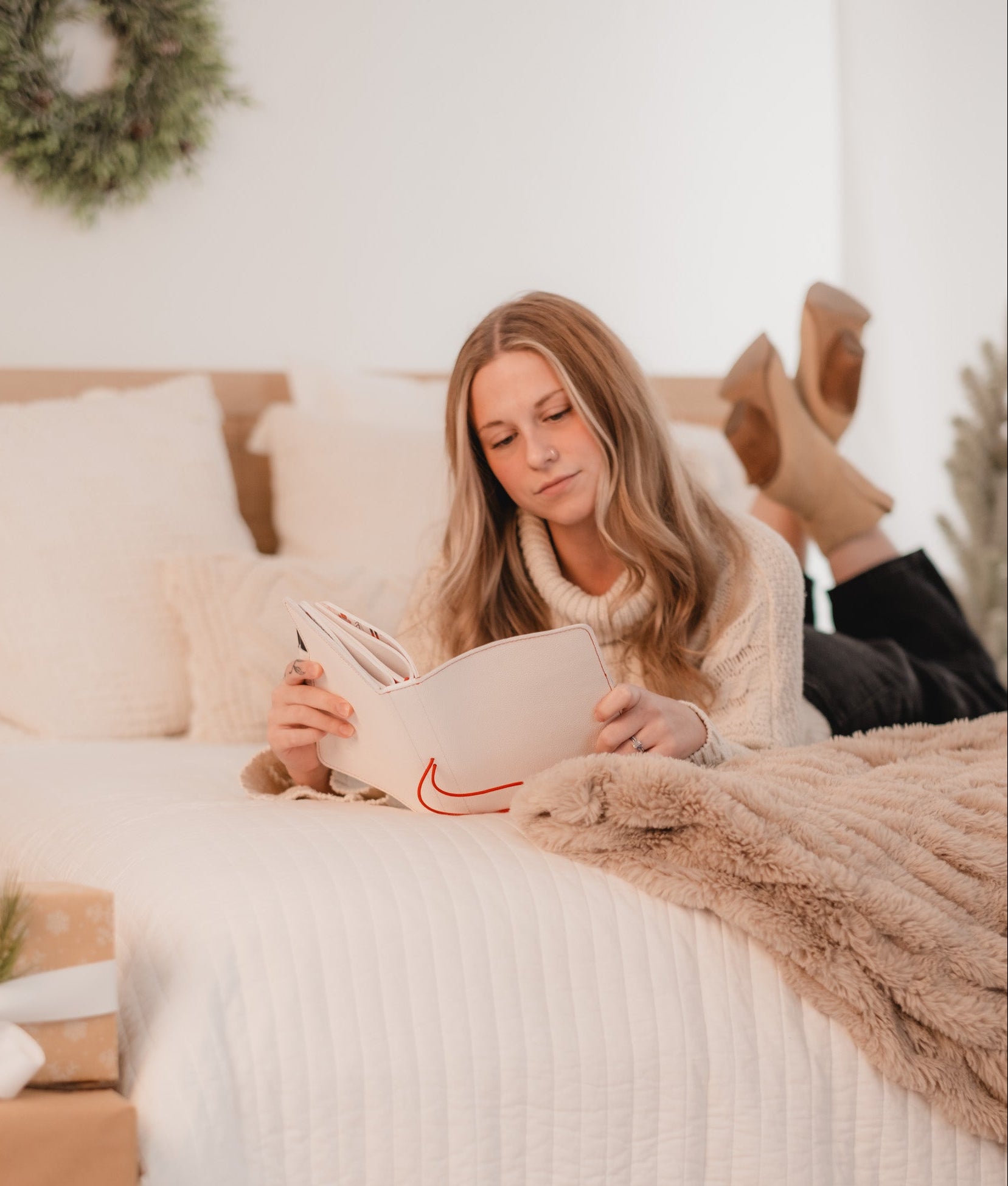 Woman reading a book on a bed with a cozy atmosphere